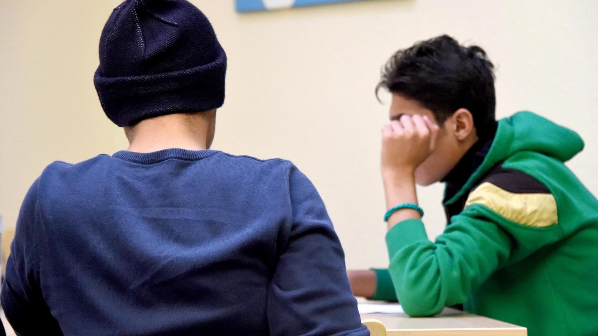 Jugendliche Flüchtlinge sitzen an einem Tisch. Jugendliche Flüchtlinge sitzen an einem Tisch.