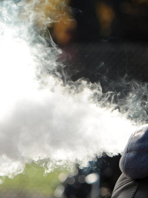Ein Mann exhaliert den Rauch einer E-Zigarette in München, Bayern