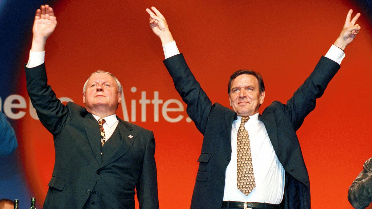 SPD-Parteichef Oskar Lafontaine (l.) und der SPD-Kanzlerkandidat Gerhard Schröder posieren bei einer gemeinsamen Wahlkampfveranstaltung in Dortmund im September 1998 kurz vor der Bundestagswahl. SPD-Parteichef Oskar Lafontaine (l.) und der SPD-Kanzlerkandidat Gerhard Schröder posieren bei einer gemeinsamen Wahlkampfveranstaltung in Dortmund im September 1998 kurz vor der Bundestagswahl.