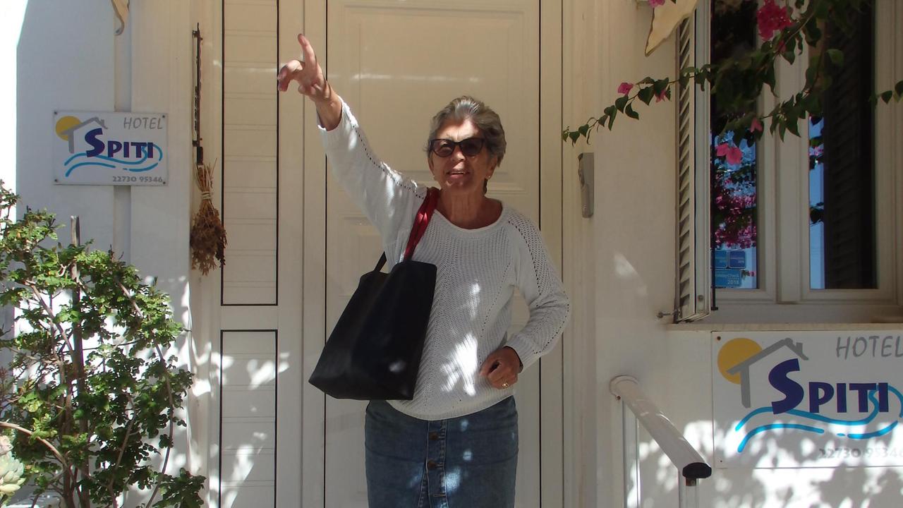 Gisela steht vor einem griechischen Haus und schaut fröhlich in die Kamera Gisela steht vor einem griechischen Haus und schaut fröhlich in die Kamera