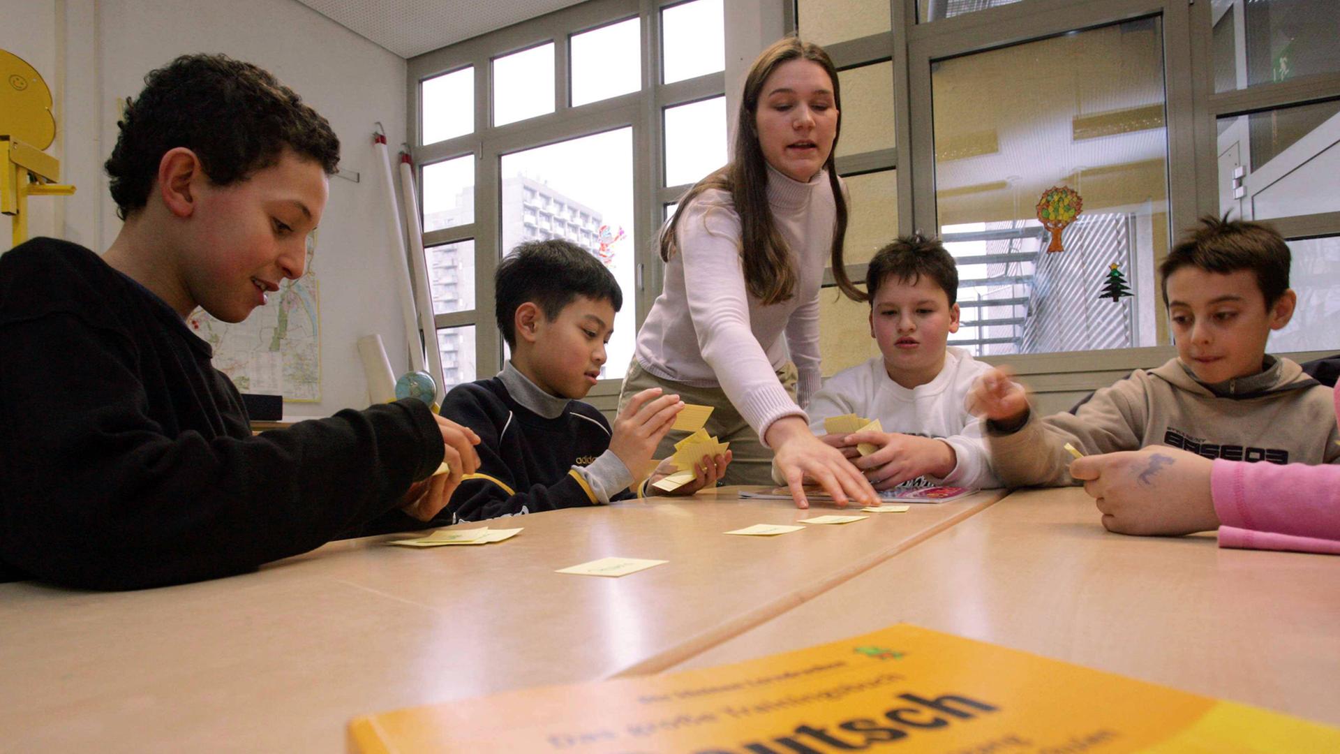 Eine Lehrerin unterrichtet Migrantenkinder in Deutsch Eine Lehrerin unterrichtet Migrantenkinder in Deutsch