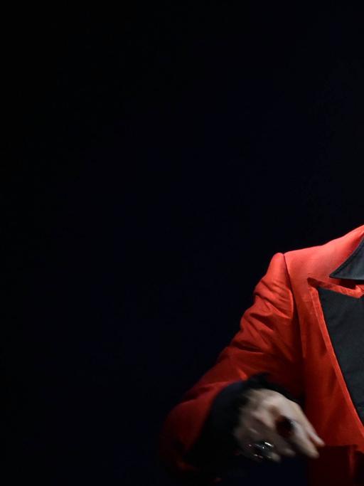 Ein Darsteller des Musicals "Miss Saigon" mit einem angeklebten kleinen Stirnmikrofon steht am 25.01.2019 in Köln bei einem Fototermin auf der Bühne.