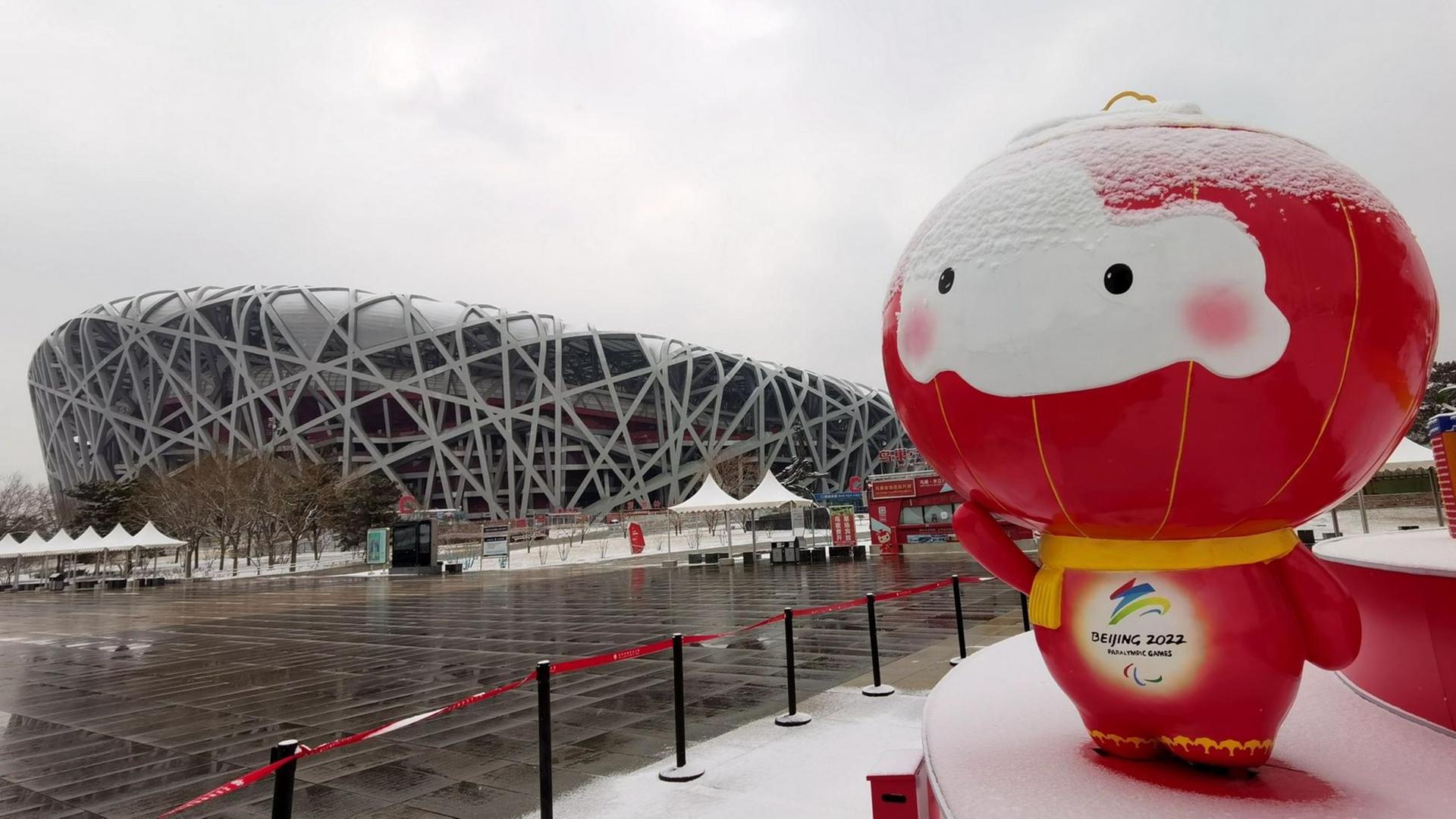 Das Maskottchen steht im Schnee vor dem Stadion. Das Maskottchen steht im Schnee vor dem Stadion.