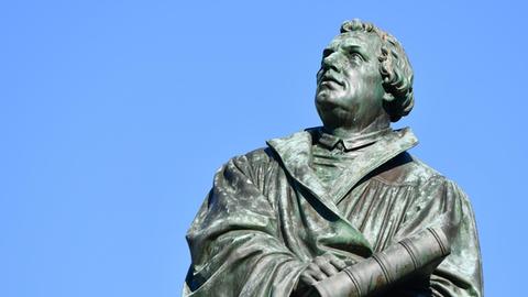 Das Bild zeigt eine Skulptur aus Bronze des Reformators Martin Luther in Worms.