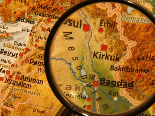 Eine Landkarte des Nahen Ostens, die irakische Hauptstadt Bagdad wird durch eine Lupe hervorgehoben.