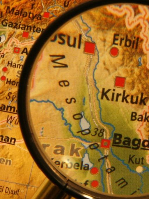 Eine Landkarte des Nahen Ostens, die irakische Hauptstadt Bagdad wird durch eine Lupe hervorgehoben.