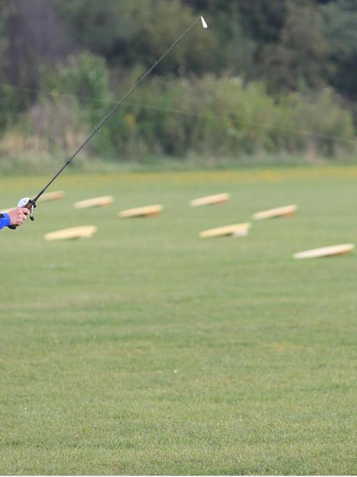 Der deutsche Jens Nagel ist 2013 bei der 38. Weltmeisterschaft im Castingsport in Halle auf der Wiese mit seiner Angel im Einsatz.