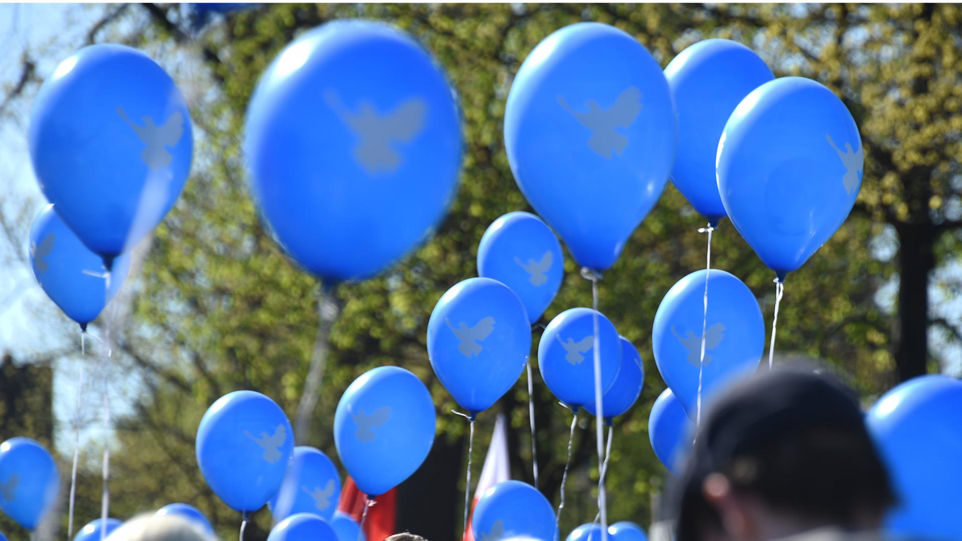 Teilnehmer des Ostermarsches halten in Wedel (Schleswig-Holstein) blaue Luftballons mit einer Friedenstaube hoch. Teilnehmer des Ostermarsches halten in Wedel (Schleswig-Holstein) blaue Luftballons mit einer Friedenstaube hoch.