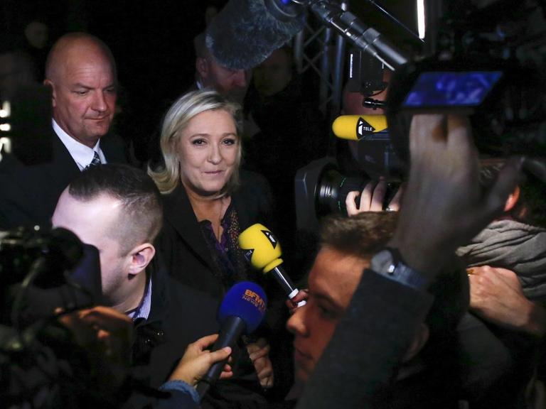 Marine Le Pen umringt von Kameras und Mikrofonen.