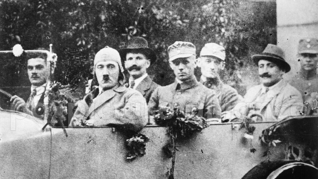 Das Schwarz-weiß-Foto zeigt Adolf Hitler mit den Freikorpsoffizieren Ulrich Graf, Major Buch und Christian Weber in einem offenen Wagen. Das Schwarz-weiß-Foto zeigt Adolf Hitler mit den Freikorpsoffizieren Ulrich Graf, Major Buch und Christian Weber in einem offenen Wagen.