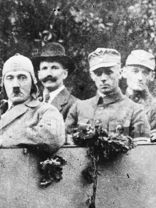 Das Schwarz-weiß-Foto zeigt Adolf Hitler mit den Freikorpsoffizieren Ulrich Graf, Major Buch und Christian Weber in einem offenen Wagen.
