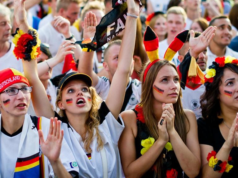 Fußballfans verfolgen am 04.07.2014 in Berlin beim "Public Viewing" am Brandenburger Tor während das WM-Viertelfinalspiel Deutschland - Frankreich.