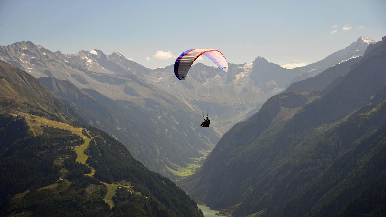 Ein Gleitschirmflieger über dem Zillertal in Tirol Ein Gleitschirmflieger über dem Zillertal in Tirol