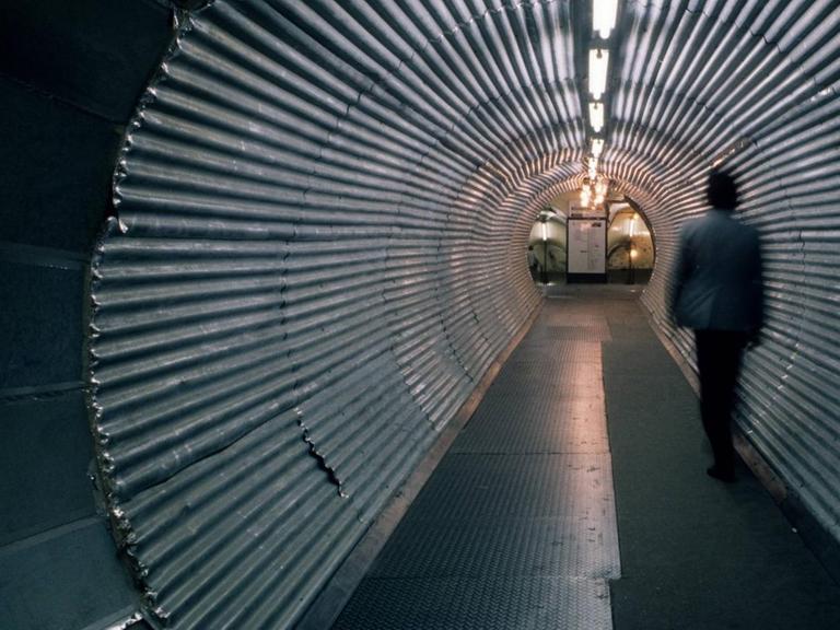 Ein Mann geht durch einen Tunnel, der zur Londoner U-Bahn führt.