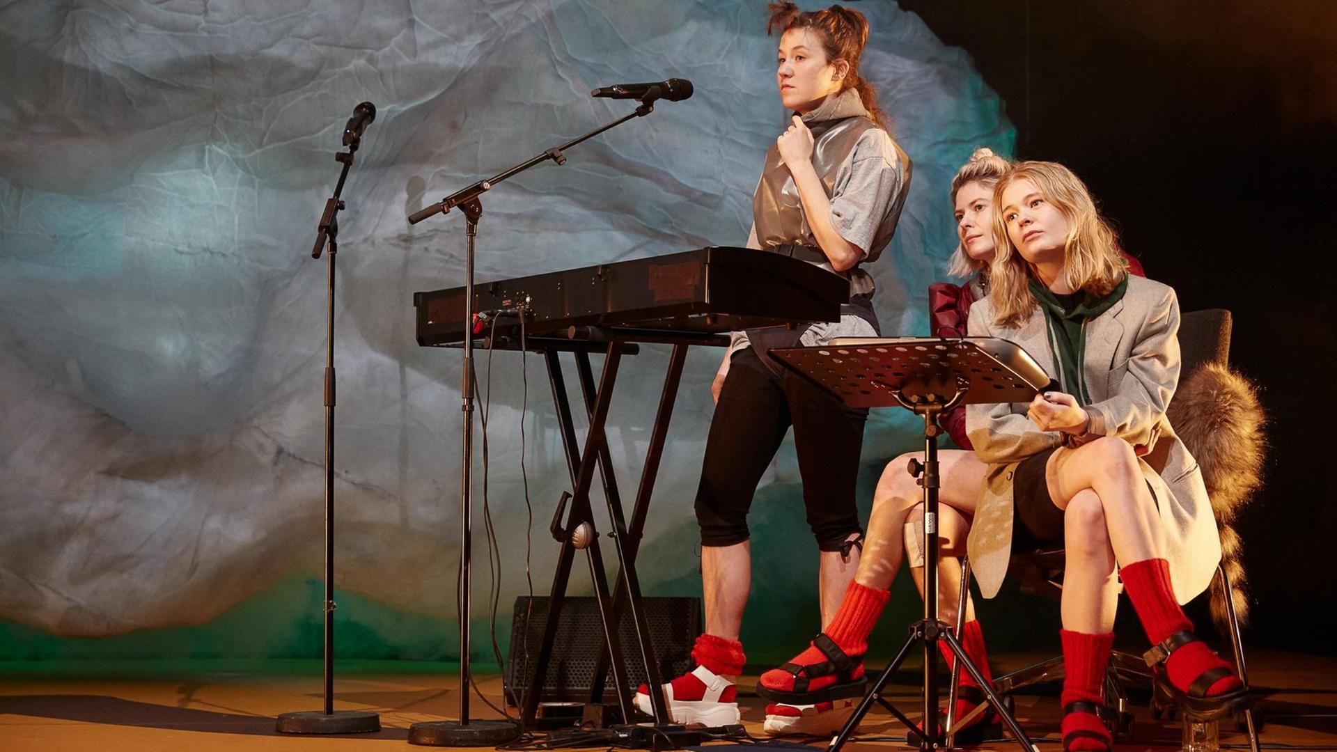 Drei Frauen sitzen bzw. stehen vor ihren Musikinstrumenten und schauen ins Leere. Drei Frauen sitzen bzw. stehen vor ihren Musikinstrumenten und schauen ins Leere.