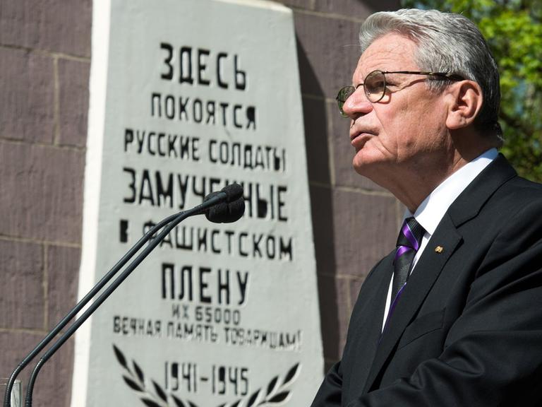 Bundespräsident Joachim Gauck spricht am 06.05.2015 in Schloß Holte-Stukenbrock (Nordrhein-Westfalen) während einer Gedenkfeier zum 70. Jahrestages des Endes des Zweiten Weltkrieges. Gauck steht vor einer Gedenksäule, auf der eine russische Inschrift an die vielen tausend sowjetischen Soldaten erinnert, die während des Zweiten Weltkrieges in deutscher Kriegsgefangenschaft ums Leben gekommen sind.