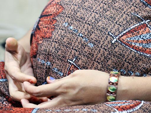 Eine indische Leihmutter hält ihre Hände vor ihren Babybauch. Sie trägt das Kind eines Paares aus den USA aus. 