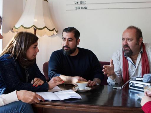 Die syrischen Journalisten Abdul Rahman Mousa, Dima AlBitar Kalaji, Alia Atassi, Rasha AlKhadra und Bassam Dawood sitzen in einem Café in Berlin-Kreuzberg.