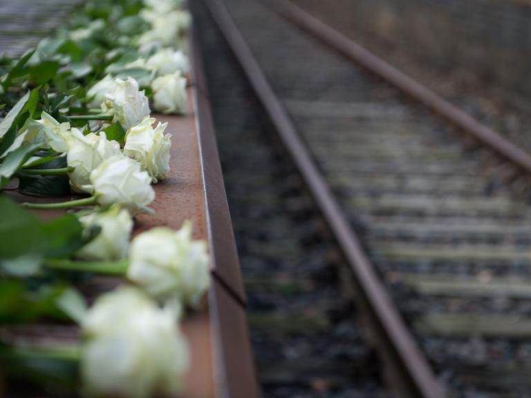 Weiße Rosen liegen neben einem Gleis: Bei der Gedenkfeier "Gleis 17" nahe dem heutigen S-Bahnhof Grunewald wurde an die erste Deportation jüdischer Berliner Bürger in ein NS-Vernichtungslager 1941 erinnert.