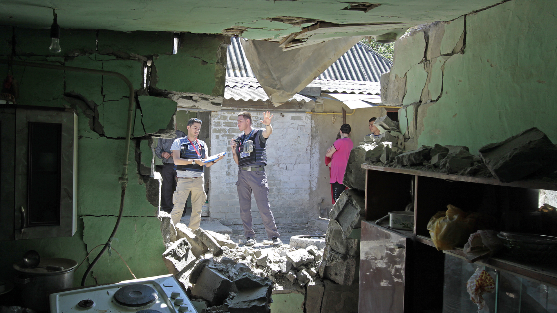 OSZE-Beobachter protokollieren die Schäden nach einem nächtlichen Bombenangriff in der ostukrainischen Region Donezk