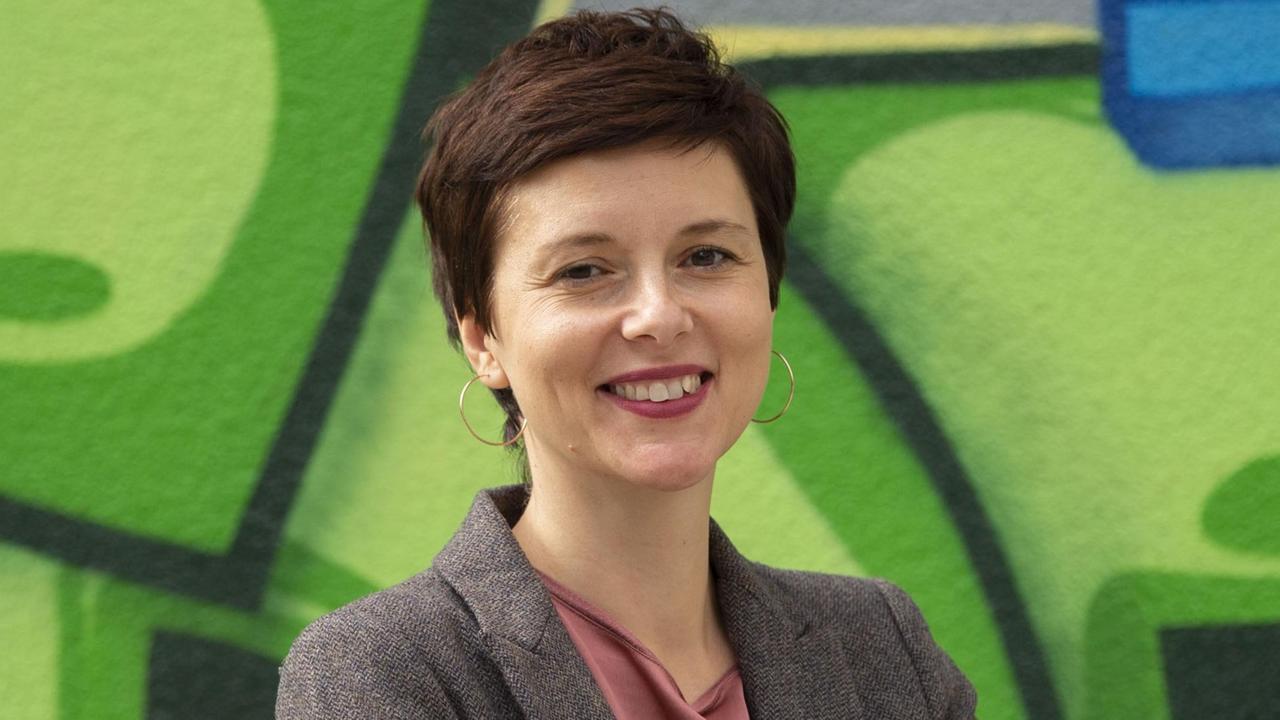 Die Berliner Integrationsbeauftragte Katarina Niewiedzial steht vor einem Wandbild im IT-Dienstleistungszentrum Berlin. 