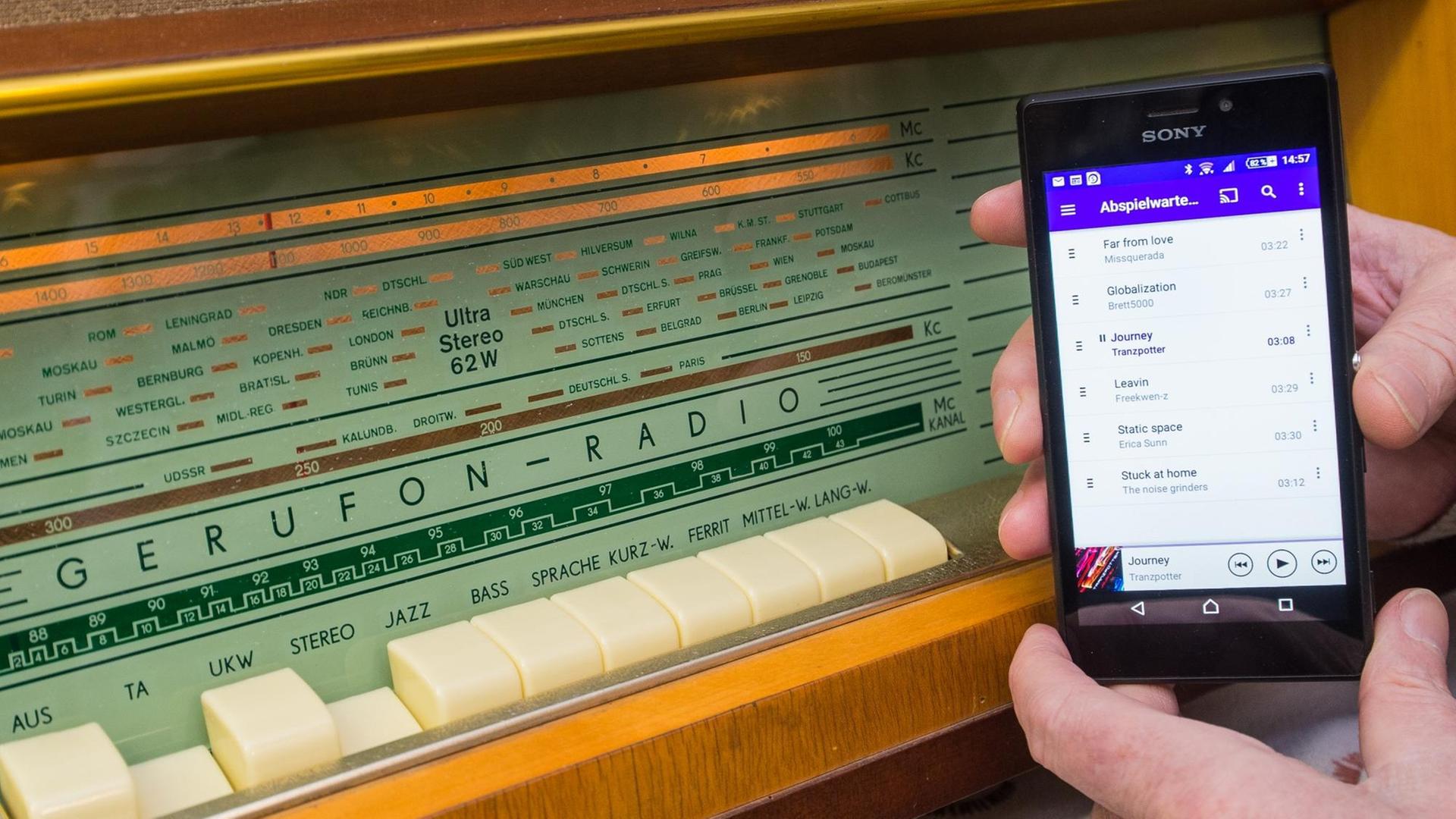 Der Radio-Sammler Karl-Heinz Boßan aus Frankfurt (Oder, Brandenburg) hält am 04.01.2016 ein Smartphone, das über eine Bluetooth-Verbindung mit einem umgebauten Gerufon-Radio aus den 60er Jahren verbunden ist. Der Radio-Sammler Karl-Heinz Boßan aus Frankfurt (Oder, Brandenburg) hält am 04.01.2016 ein Smartphone, das über eine Bluetooth-Verbindung mit einem umgebauten Gerufon-Radio aus den 60er Jahren verbunden ist.