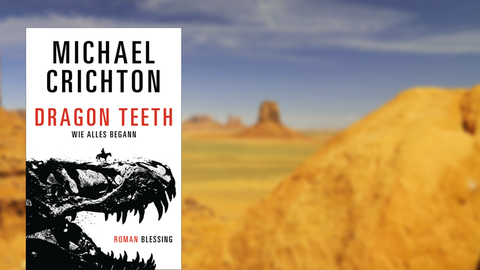 Im Vordergrund das Buchcover von Michael Crichtons "Dragon Teeth", im Hintergrund das Monument Valley in Arizona.