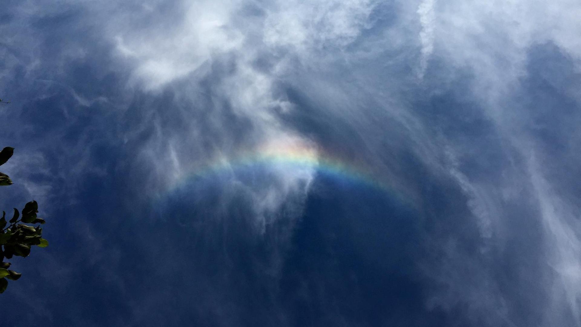 Auf blauem Himmel ist ein kleiner Regenbogen zu sehen. Auf blauem Himmel ist ein kleiner Regenbogen zu sehen.