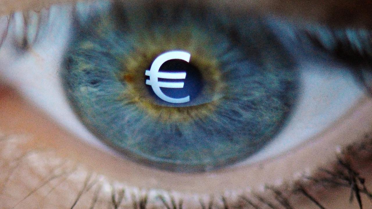 Ein Eurozeichen spiegelt sich im Auge einer Frau. 