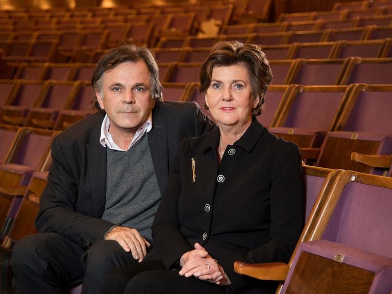 Markus Hinterhäuser und Helga Rabl-Stadler sitzen im Zuschauerraum eines leeren Theaters.