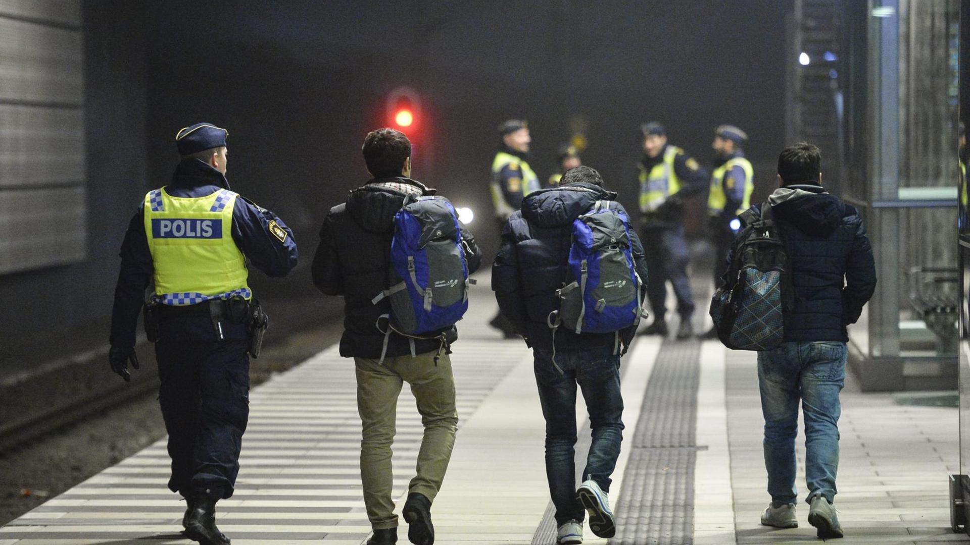 Ein schwedischer Polizist mit Flüchtlingen am Bahnhof Hyllie in der Nähe von Malmoe. Ein schwedischer Polizist mit Flüchtlingen am Bahnhof Hyllie in der Nähe von Malmoe.