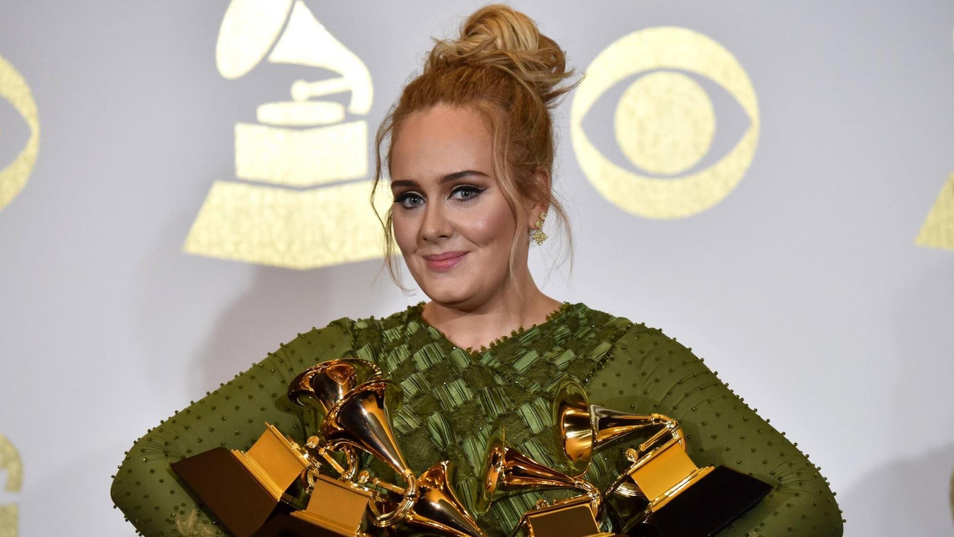 Adele im grünen Kleid mit fünf Grammy Awards in den Armen