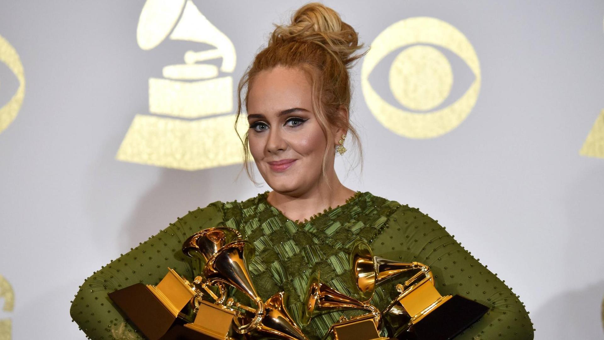 Adele im grünen Kleid mit fünf Grammy Awards in den Armen Adele im grünen Kleid mit fünf Grammy Awards in den Armen