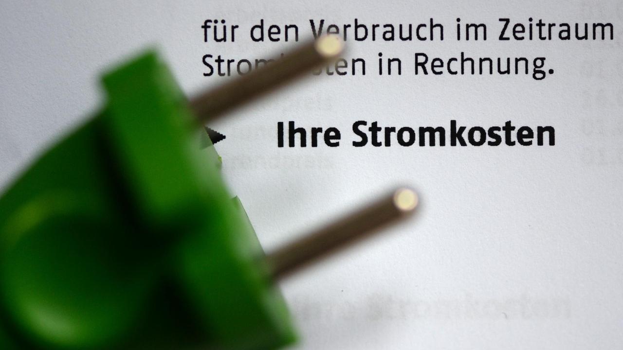 Ein grüner Stromstecker liegt am 03.11.2013 in Berlin auf einer Stromrechnung. Ein grüner Stromstecker liegt am 03.11.2013 in Berlin auf einer Stromrechnung.