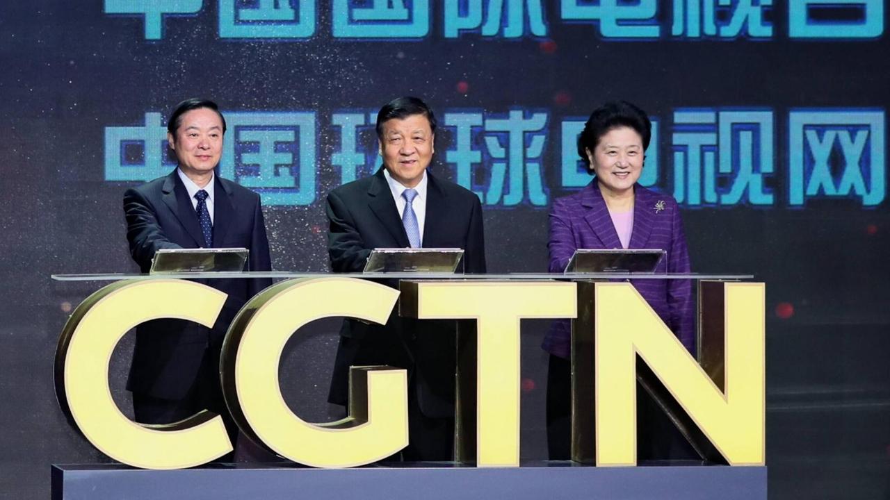Zwei chinesische Männer und eine Frau sitzen auf einem Podium, vor ihnen der Schriftzug CGTN. Zwei chinesische Männer und eine Frau sitzen auf einem Podium, vor ihnen der Schriftzug CGTN.