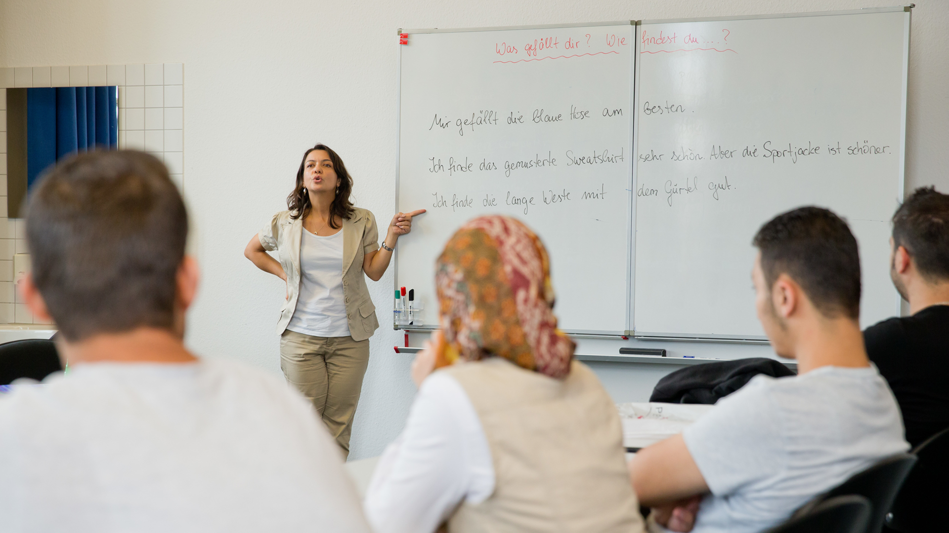 Die Deutschlehrerin Gülsen Landshuter geht mit Teilnehmern eines Integrationskurses im Bildungszentrum in Nürnberg eine Sprachübung durch.