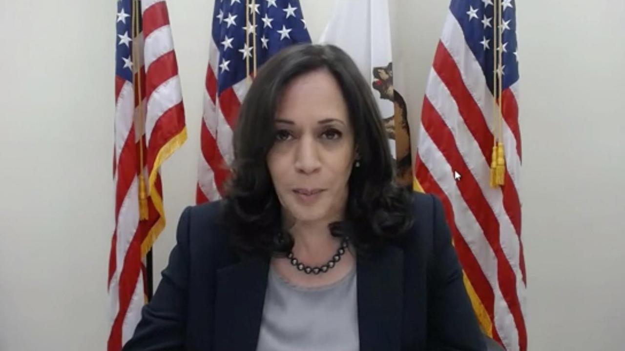 Die US-Demokratin Kamala Harris sitzt vor US-Flaggen. Die US-Demokratin Kamala Harris sitzt vor US-Flaggen.