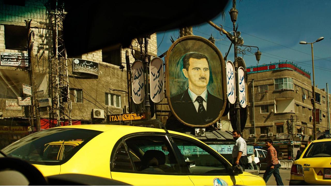 Auf einem Platz in Syriens Hauptstadt Damaskus hängt ein großes Bild von Machthaber Baschar al-Assad