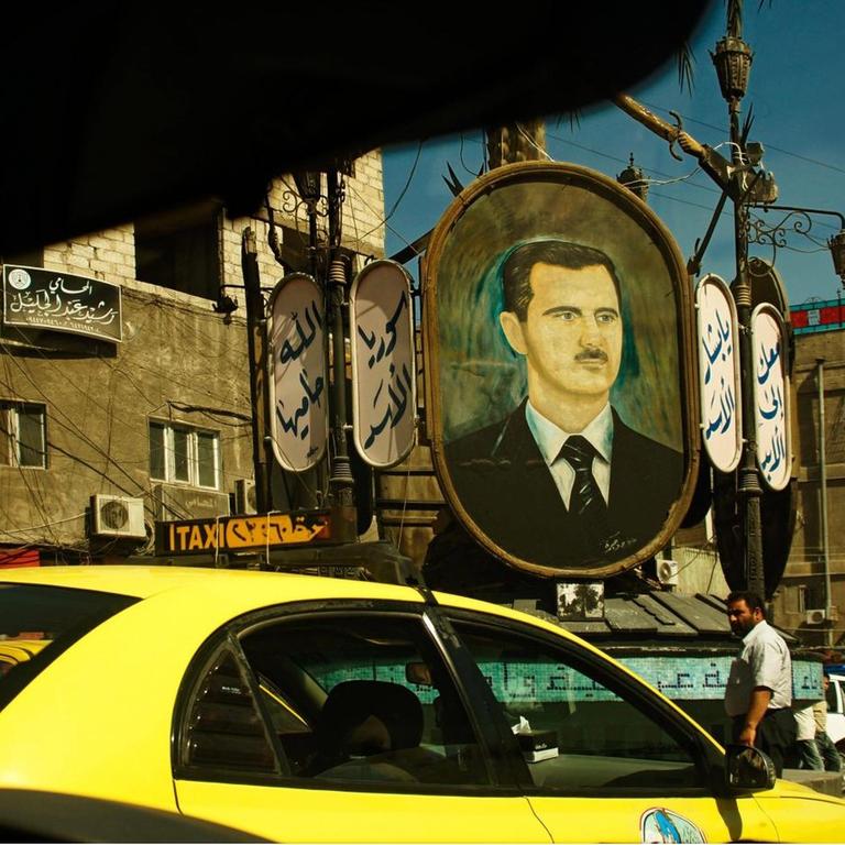 Auf einem Platz in Syriens Hauptstadt Damaskus hängt ein großes Bild von Machthaber Baschar al-Assad