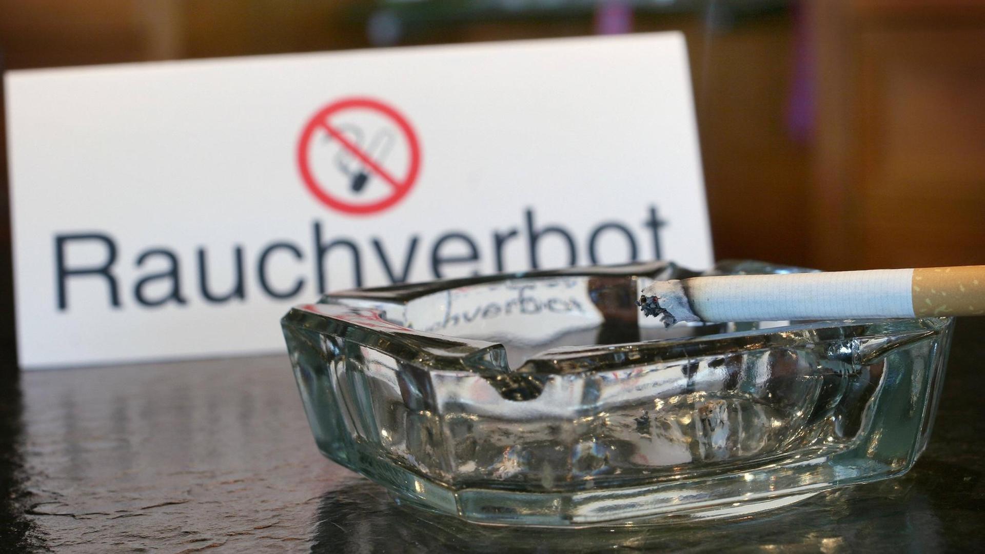 Ein Aschenbecher und ein Nichtraucherschild. Seit zehn Jahren gilt das bundesweite Rauchverbot in Gaststätten Ein Aschenbecher und ein Nichtraucherschild. Seit zehn Jahren gilt das bundesweite Rauchverbot in Gaststätten