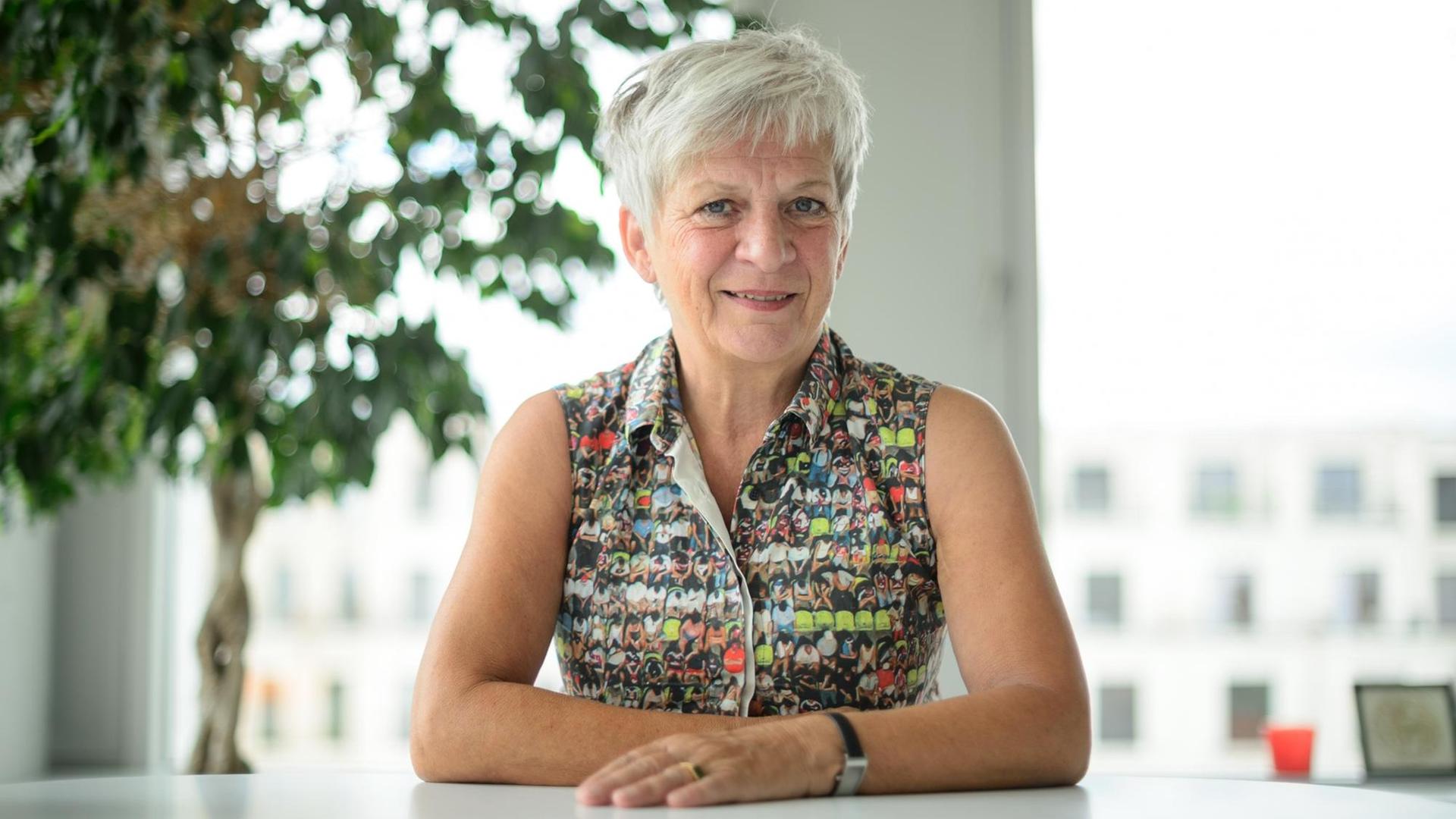 Barbara Unmüßig sitzt an einem Tisch. Barbara Unmüßig sitzt an einem Tisch.