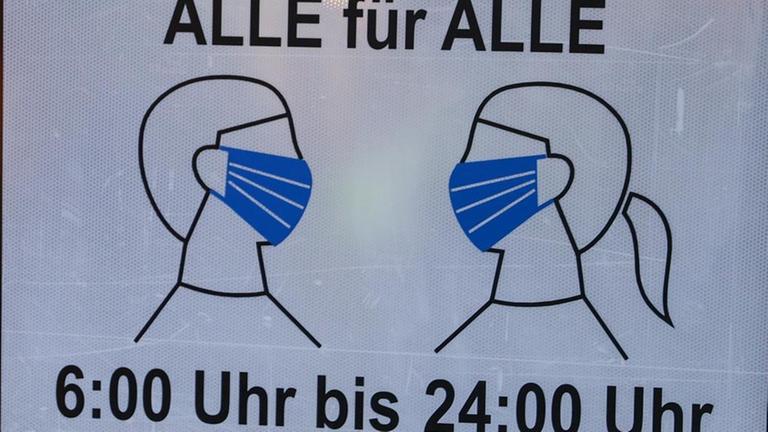 Ein Schild mit der Aufschrift "Alle für Alle - 6:00 bis 24:00 Uhr" weist auf die Maskenpflicht hin. Ein Schild mit der Aufschrift "Alle für Alle - 6:00 bis 24:00 Uhr" weist auf die Maskenpflicht hin.