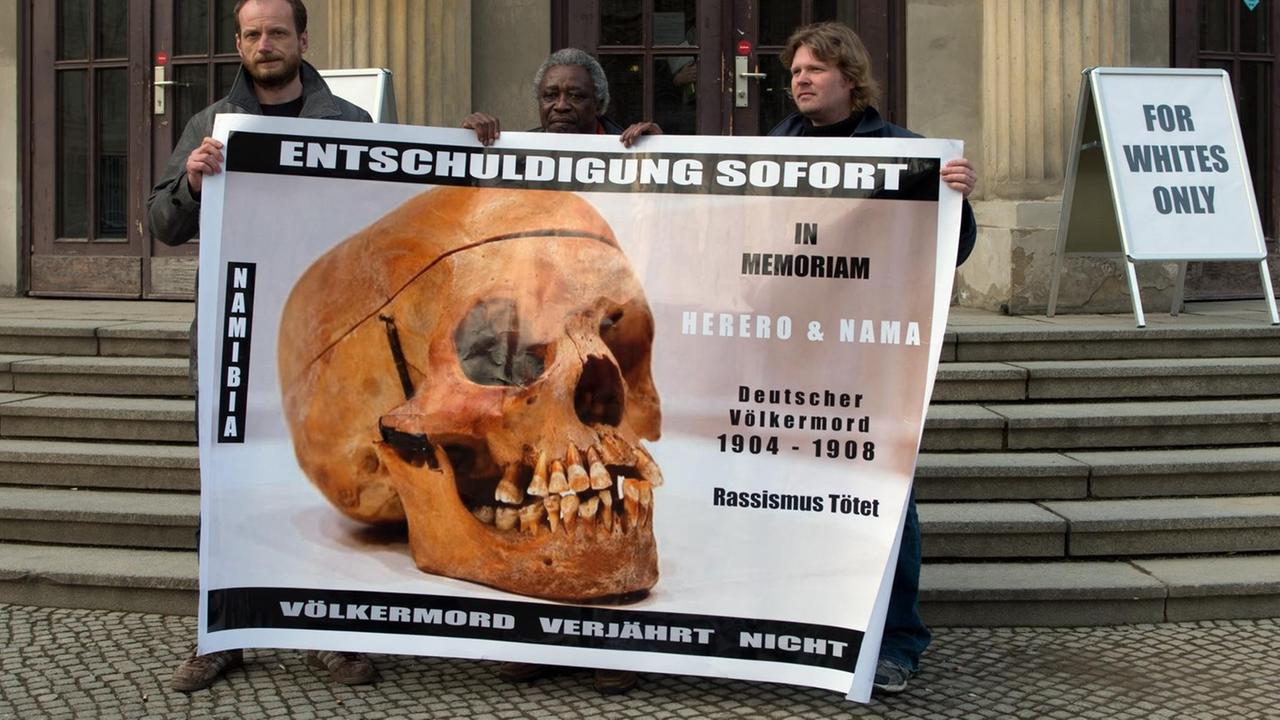 Demonstranten mit einem Transparent "Entschuldigung sofort - Völkermord verjährt nicht" vor einem Gebäude der Charite in Berlin Demonstranten mit einem Transparent "Entschuldigung sofort - Völkermord verjährt nicht" vor einem Gebäude der Charite in Berlin
