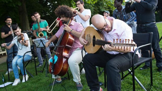 Die Band "Banda Internationale" spielt im Großen Garten in Dresden. In der Band musizieren Einheimische und Geflüchtete zusammen.