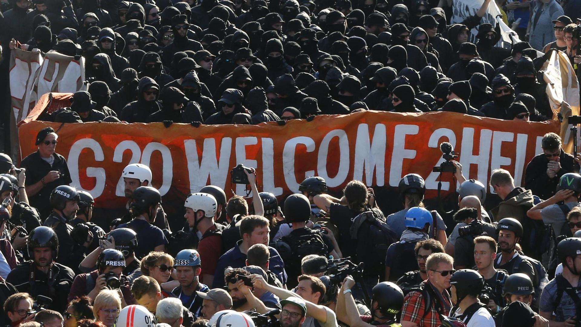 Schwarz gekleidete Demonstranten und Polizisten bei der Kundgebung "Welcome to Hell" in Hamburg. Schwarz gekleidete Demonstranten und Polizisten bei der Kundgebung "Welcome to Hell" in Hamburg.