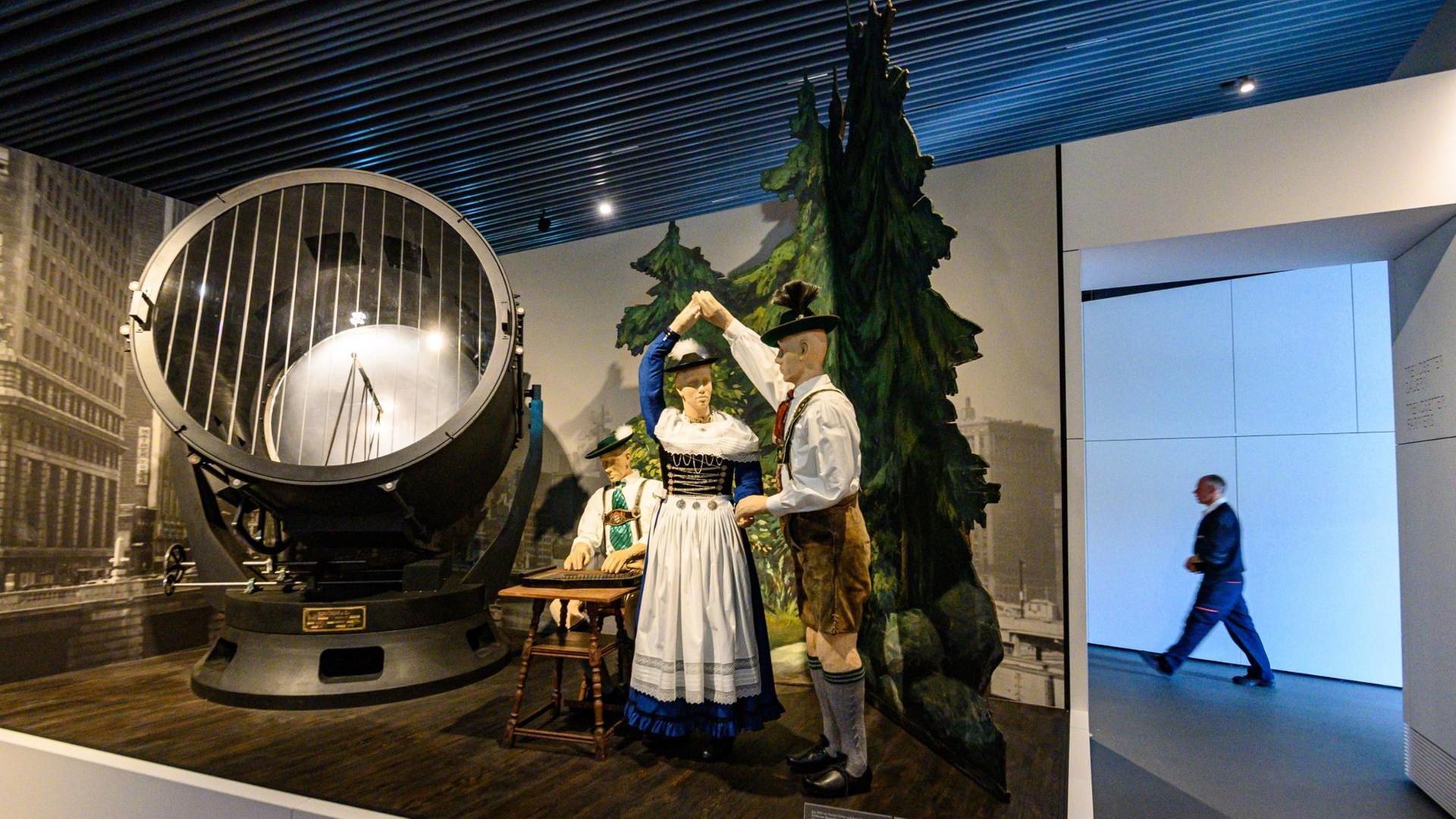 Eine Theaterkulisse des Schlierseer Bauerntheaters steht im Museum des Hauses der Bayerischen Geschichte neben einem Schukert-Strahler (l). Eine Theaterkulisse des Schlierseer Bauerntheaters steht im Museum des Hauses der Bayerischen Geschichte neben einem Schukert-Strahler (l).