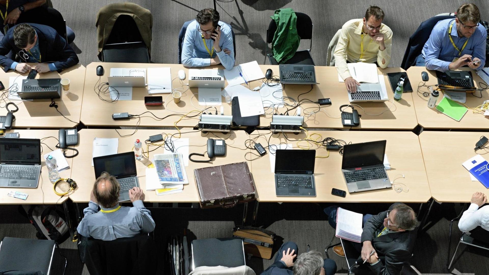 Journalisten sitzen mit Laptops an einem Tisch im Pressezentrum im Foyer des Justus-Lipsius-Gebäude in Brüssel Journalisten sitzen mit Laptops an einem Tisch im Pressezentrum im Foyer des Justus-Lipsius-Gebäude in Brüssel
