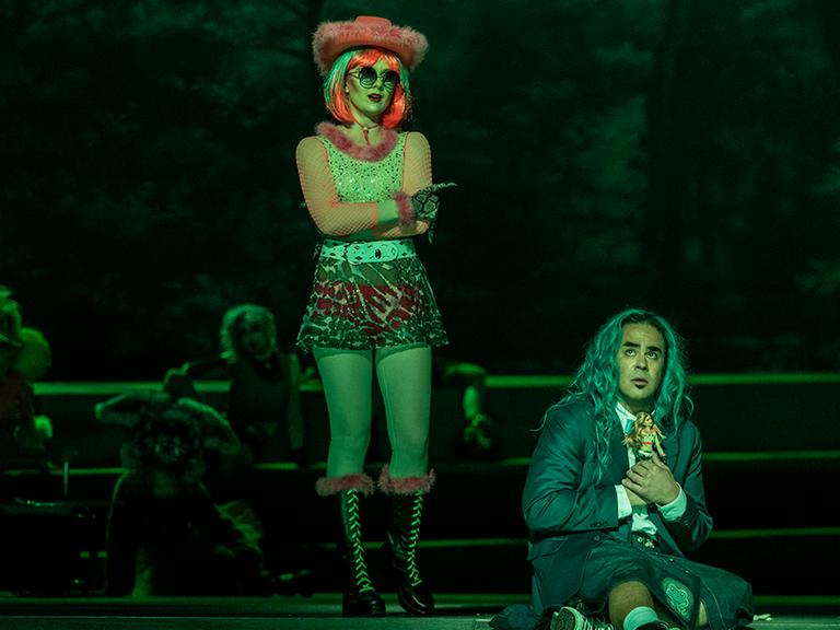 Auf der Bühne der Semperopfer in Dresden stehen Iulia Maria Dan in den Rollen Thalie/Clarine, zur rechten Seite kniet Philippe Talbot in der Rolle der Titelhelding Platée.