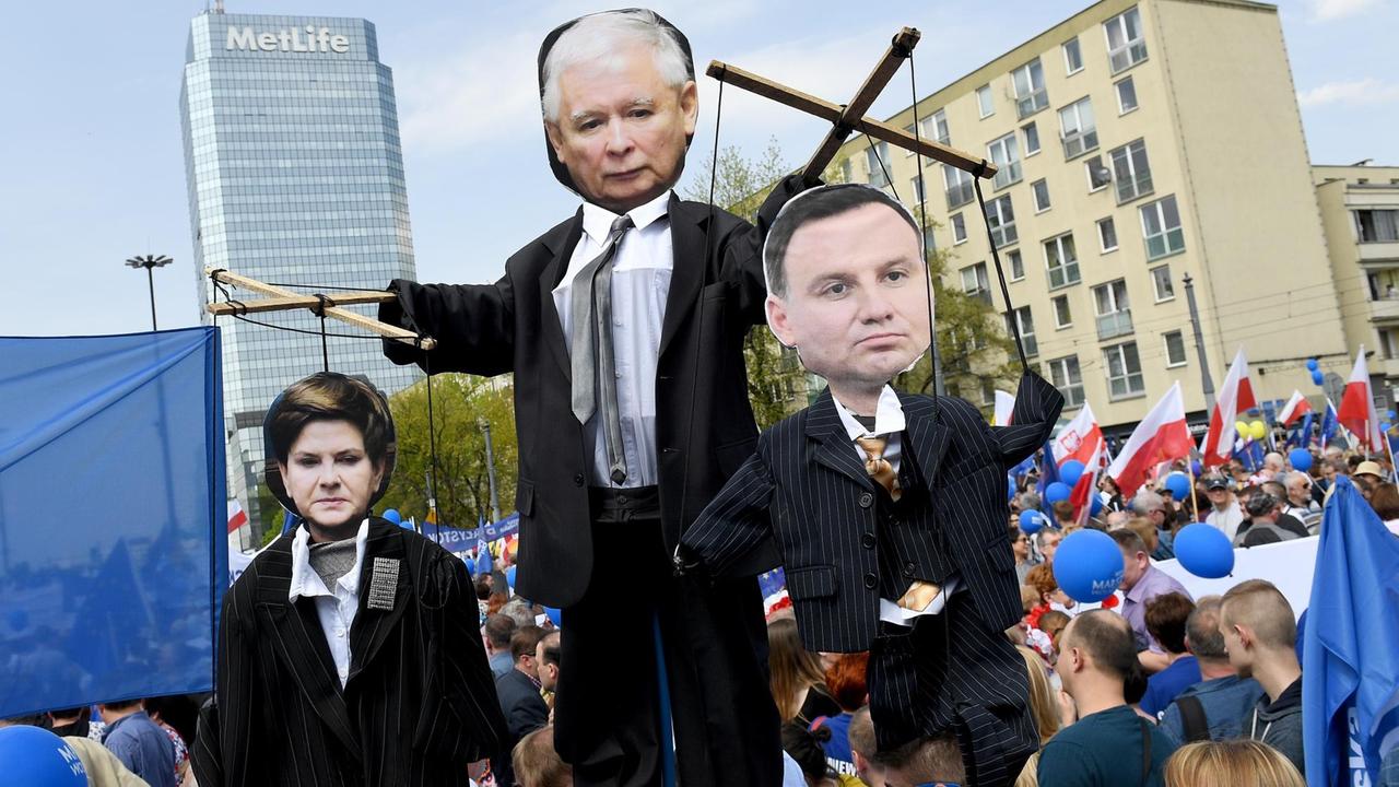 Die Figuren von PiS-Chef Jaroslaw Kaczynski (M), Ministerpräsidentin Beata Szydlo und dem polnischen Präsidenten Andrzej Duda als Marionetten inmitten von Demonstranten, die am 6.5.17 in Warschau auf die Straße gingen. 
