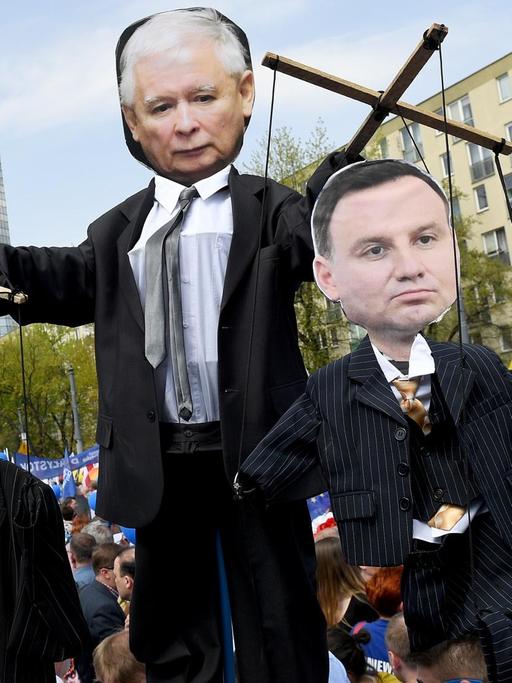 Die Figuren von PiS-Chef Jaroslaw Kaczynski (M), Ministerpräsidentin Beata Szydlo und dem polnischen Präsidenten Andrzej Duda als Marionetten inmitten von Demonstranten, die am 6.5.17 in Warschau auf die Straße gingen.